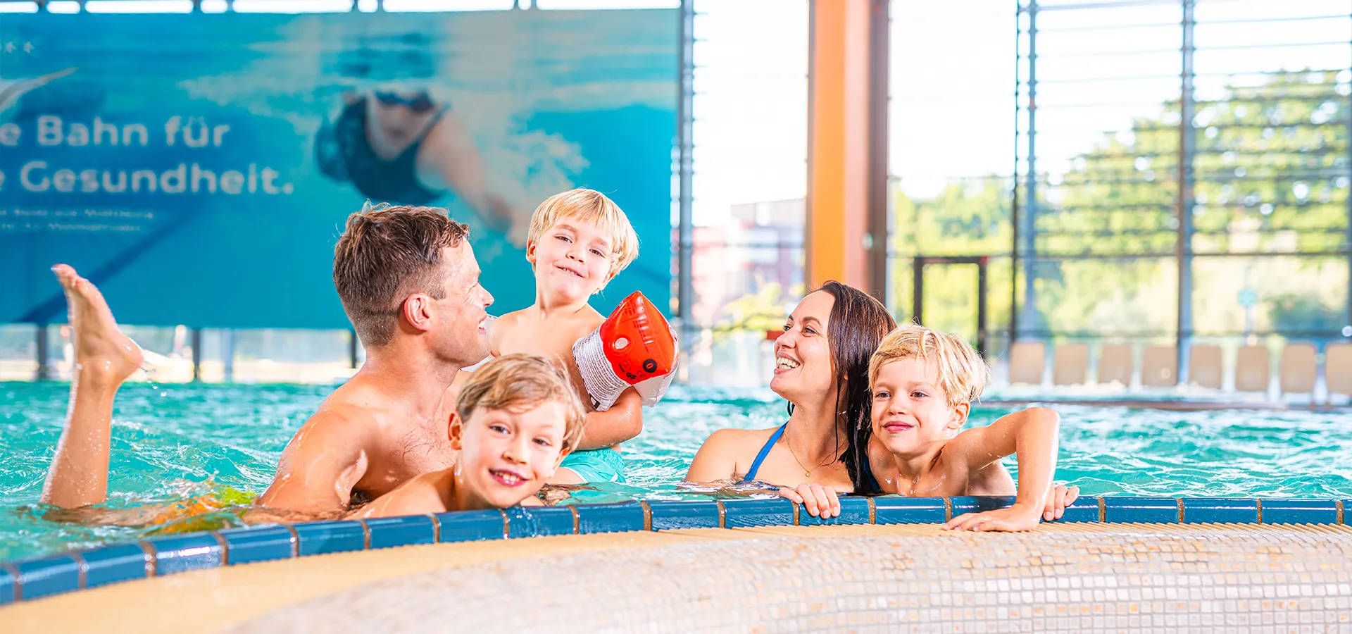 Am Rand des Mediterranbeckens positioniert genießt eine fünfköpfige Familie mit drei Söhnen das angenehem warme Wasser.